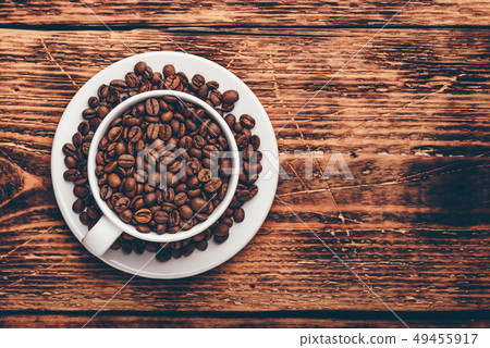 White cup full of roasted coffee beans 49455917