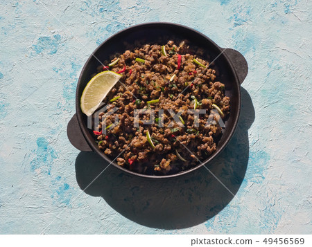 Indian minced meat Qeema on a sunny blue table. Indian minced meat Qeema on a sunny blue table. 49456569