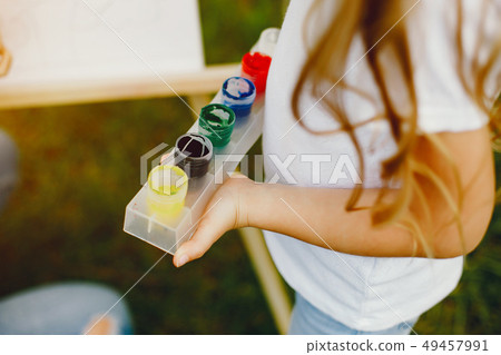 Cute little girl painting in a park 49457991