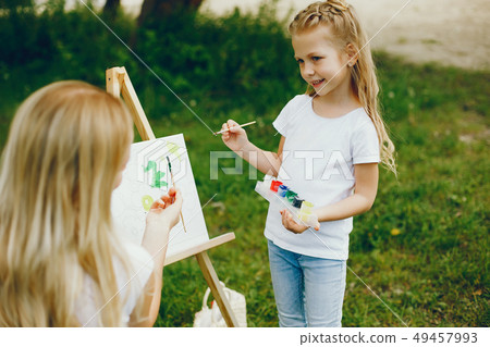 Mother with daughter drawing in a park Mother with daughter drawing in a park 49457993