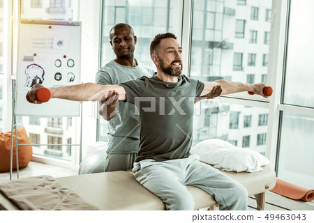 Joyful brunette male having training with his therapist 49463043