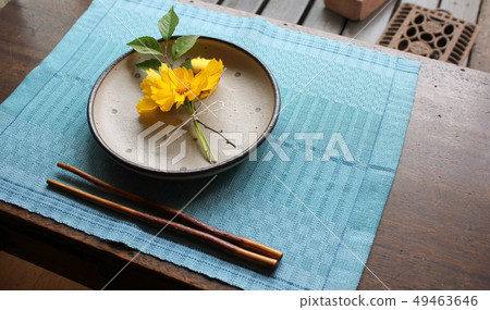 Light blue placemat and dish with yellow flowers 49463646