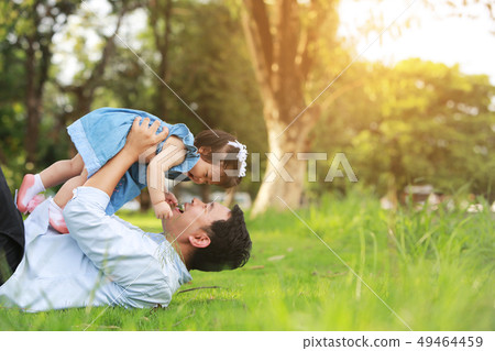 Father and little girl play lying on grass, low 49464459
