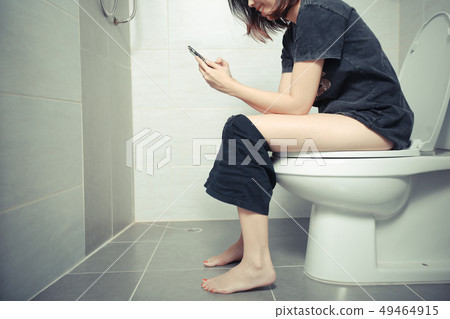 Woman using a smartphone on toilet in morning. 49464915