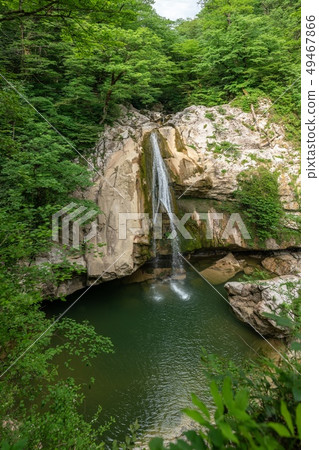 A high waterfall falls from a cliff A high waterfall falls from a cliff 49467866