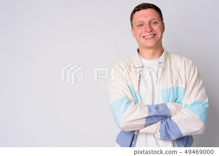 Portrait of happy young man smiling with arms crossed 49469000