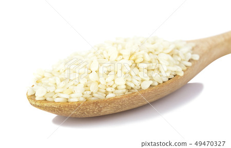 white sesame seeds in wooden spoon on white 49470327