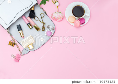 Women's handbag and accessories on a pink 49473383