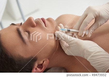 Young man on rejuvenate procedure of chin Young man on rejuvenate procedure of chin 49473932