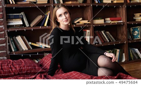 Young pretty pregnant woman in black dress in studio Young pretty pregnant woman in black dress in studio 49475684