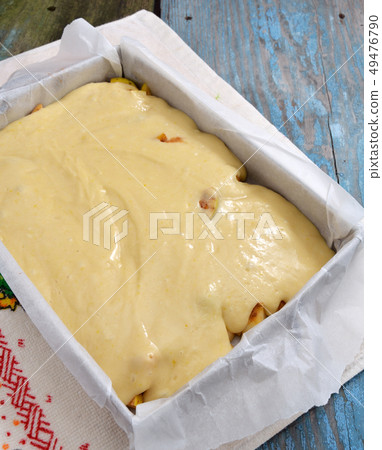 Dough with apples on a baking sheet for roasting. 49476790