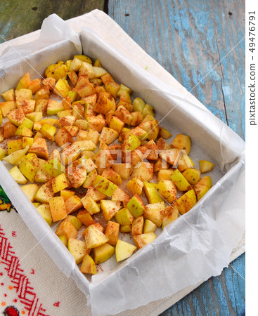 Apples with cinnamon on a baking sheet for 49476791