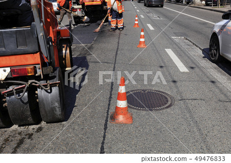 Road orange cones enclose the work crew and road Road orange cones enclose the work crew and road 49476833