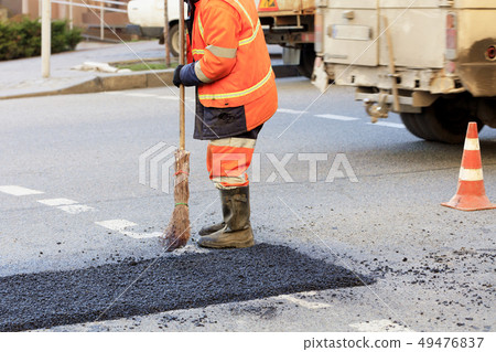 A road builder collects fresh asphalt 49476837