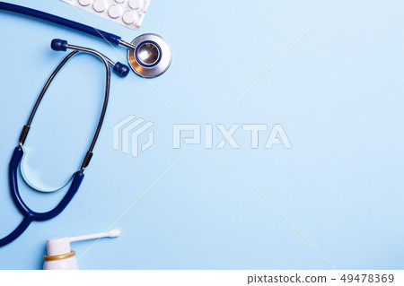 Cold medicine and phonendoscope on a blue background. Cold medicine and phonendoscope on a blue background. 49478369