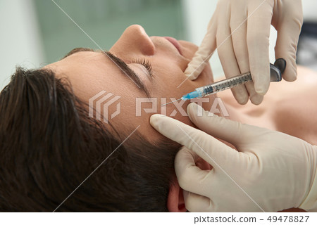 Man on anti-wrinkling procedure of crows feet Man on anti-wrinkling procedure of crows feet 49478827