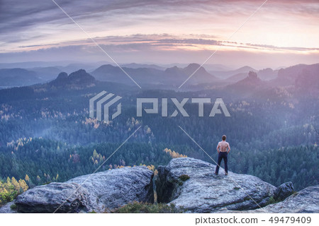 Athletic man with muscular body on cliff 49479409