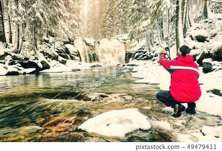 Thoughtful man in red warm jacket with phone in 49479411