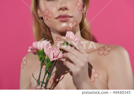 Close up blonde woman with carnation in hand Close up blonde woman with carnation in hand 49480345
