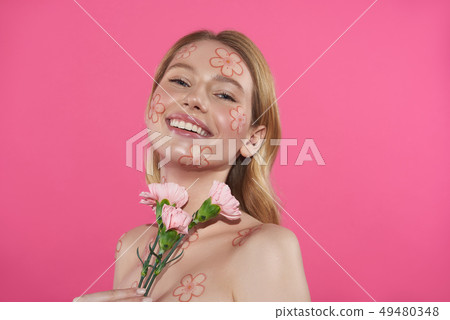 Graceful happy blonde woman posing with carnation Graceful happy blonde woman posing with carnation 49480348