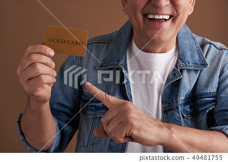 Close up photo of the gold card in hand of smiling person 49481755
