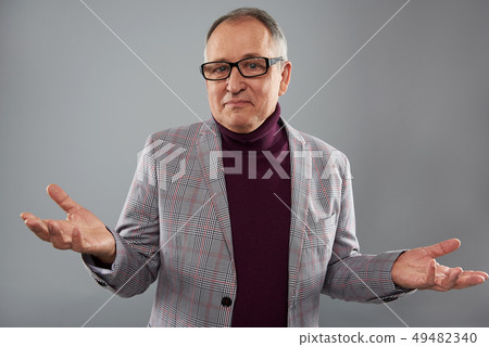 Adult man making helpless gesture while standing alone 49482340