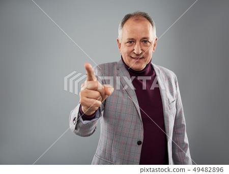 Confident adult man pointing his finger and smiling 49482896