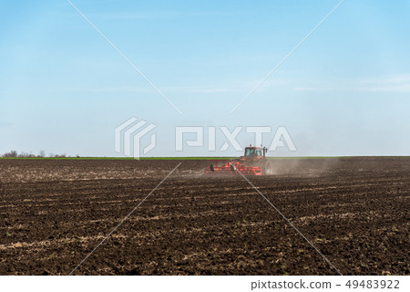Tractor plowing fields. 49483922