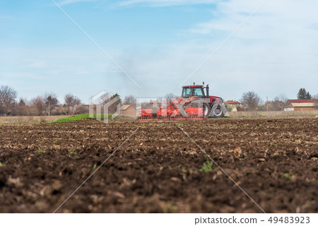 Tractor plowing fields. 49483923