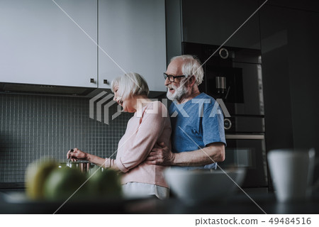Happy senior couple cooking on kitchen at home Happy senior couple cooking on kitchen at home 49484516