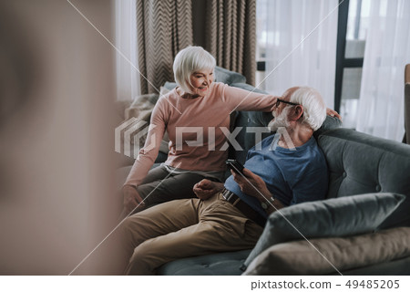 Beloved elder couple sitting on sofa at home 49485205