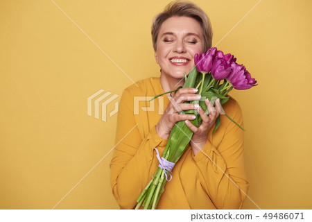 Portrait of charming woman with cute bouquet of purple tulips in arms Portrait of charming woman with cute bouquet of purple tulips in arms 49486071