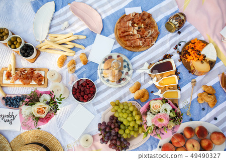 Summer picnic blanket with tasty food and snacks Summer picnic blanket with tasty food and snacks 49490327