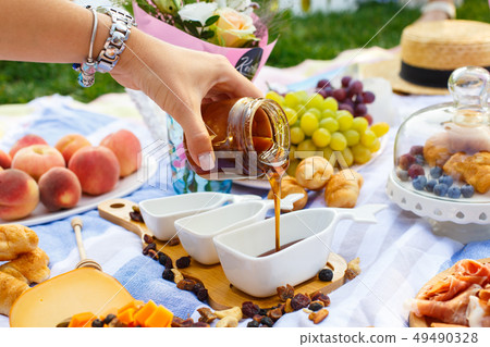 Woman hand pours honey from transparent bottle to Woman hand pours honey from transparent bottle to 49490328