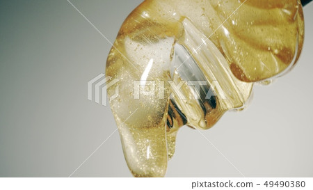 Glass honey dipper, macro shot 49490380