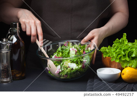 Woman chef in the kitchen preparing salad. 49492257