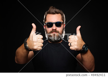 A handsome, strong man shows two thumbs up. 49492411