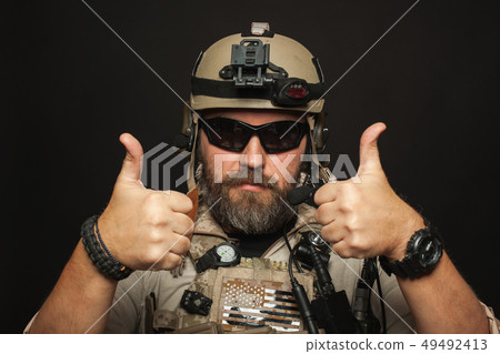 Brutal man in military uniform shows two fingers. 49492413