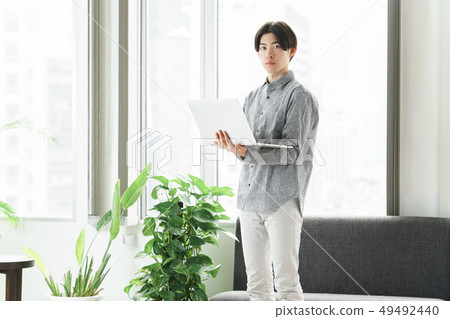 Freelance engineer operating a PC at the window 49492440