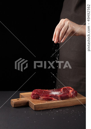 Chef's cooking new York beef steak. 49492562