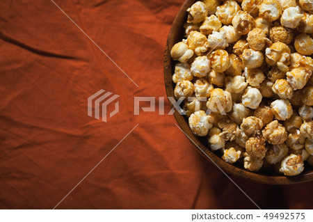 Wooden bowl with sweet popcorn. 49492575