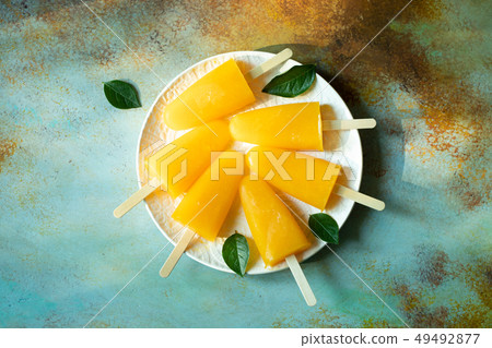 Orange popsicles with juice. 49492877