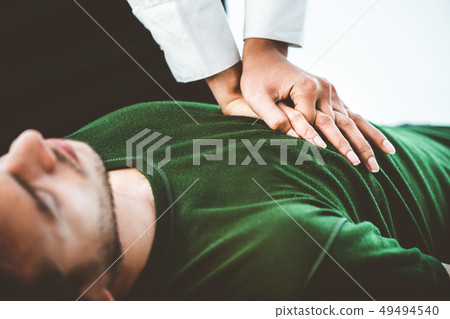 Rescuer hands doing CPR on heart attacked man. Rescuer hands doing CPR on heart attacked man. 49494540