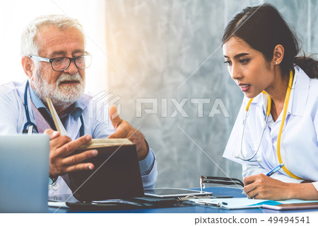 Senior male doctor working with another doctor. 49494541