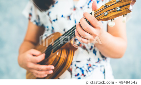Happy woman musician playing ukulele in studio. Happy woman musician playing ukulele in studio. 49494542