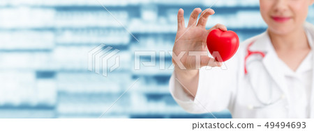 Doctor holding a red heart at hospital office. 49494693