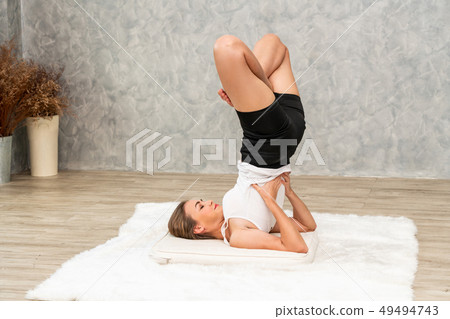 Young woman yoga on carpet at home living room. 49494743