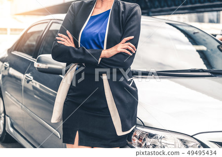 Confident business woman standing beside the car. Confident business woman standing beside the car. 49495434