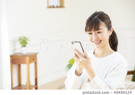 A woman operating a smartphone 49499124