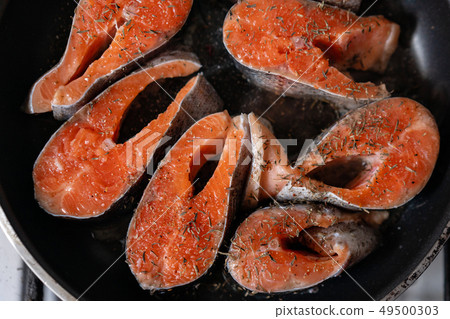 Close-up of raw pink salmon steaks in a frying pan, top view. Fresh seafood for frying. 49500303